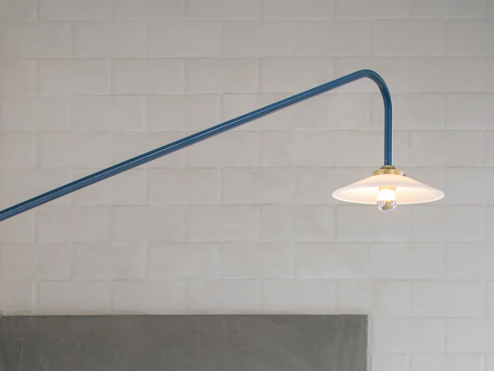 Minimal hanging tube lamp by Valerie Objects above dining table