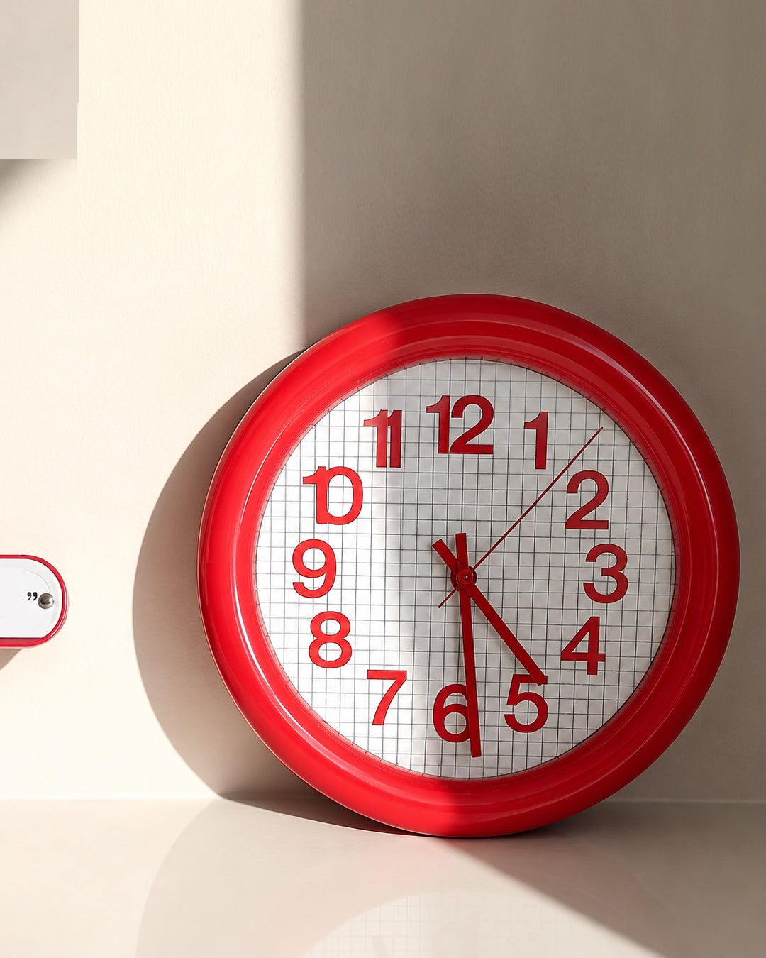 round grid wall clock shown mounted in a kitchen setting