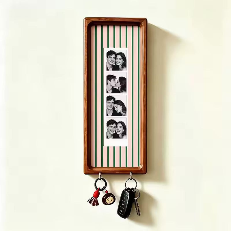 Pink and green stripe wood photo strip frame with key hooks, studio shot