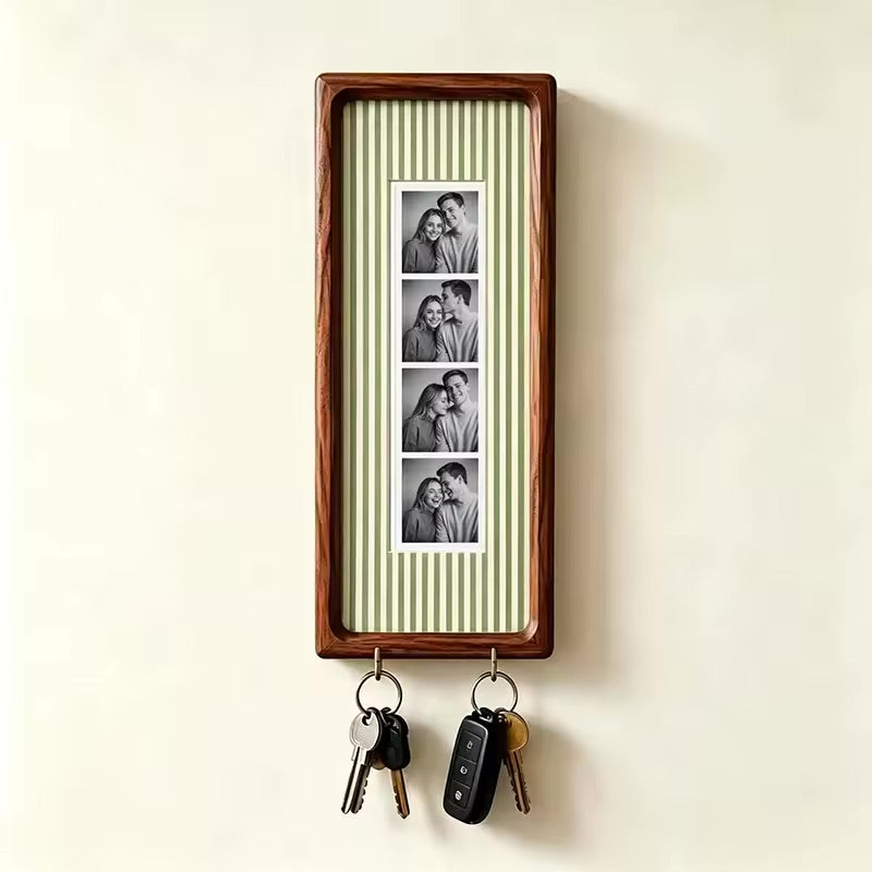 Sage green pinstripe wood photo strip frame with key hooks, studio shot