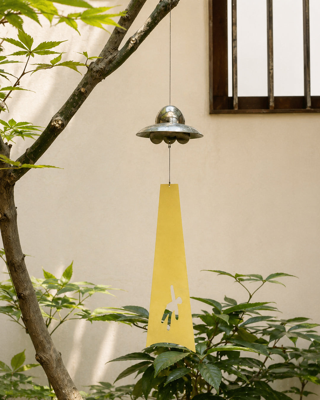 UFO wind chime hanging in a courtyard setting
