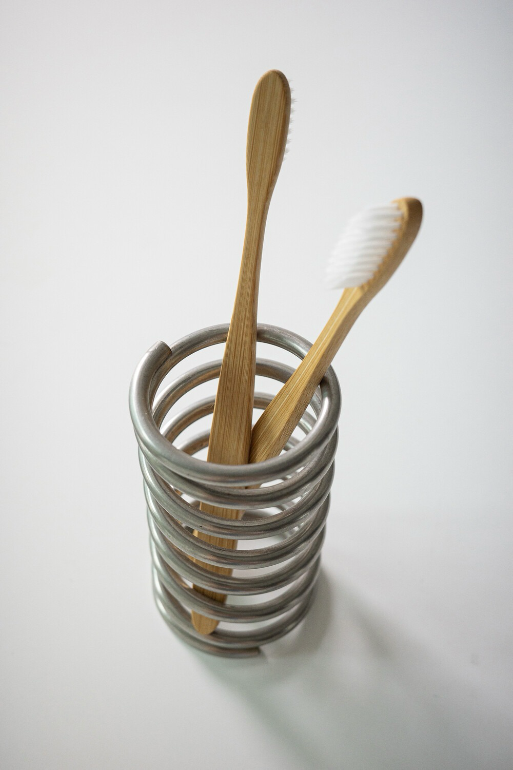 stainless steel spring stand - cylindrical holder 2x4.5" small durable closeup detail shot showing texture and craftsmanship