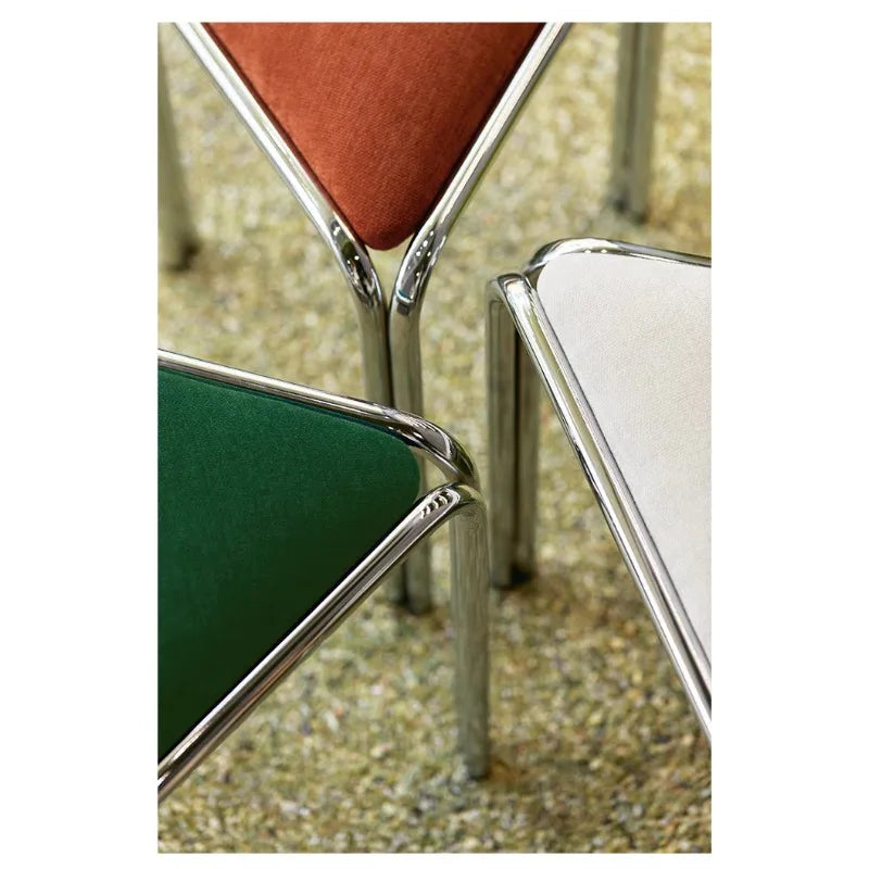 Close-up of chrome tube leg joints on triangle stacking stools