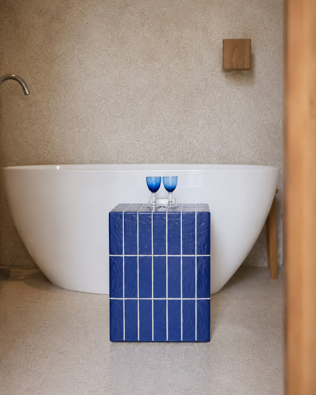 blue mosaic cube table shown styled beside a bathtub