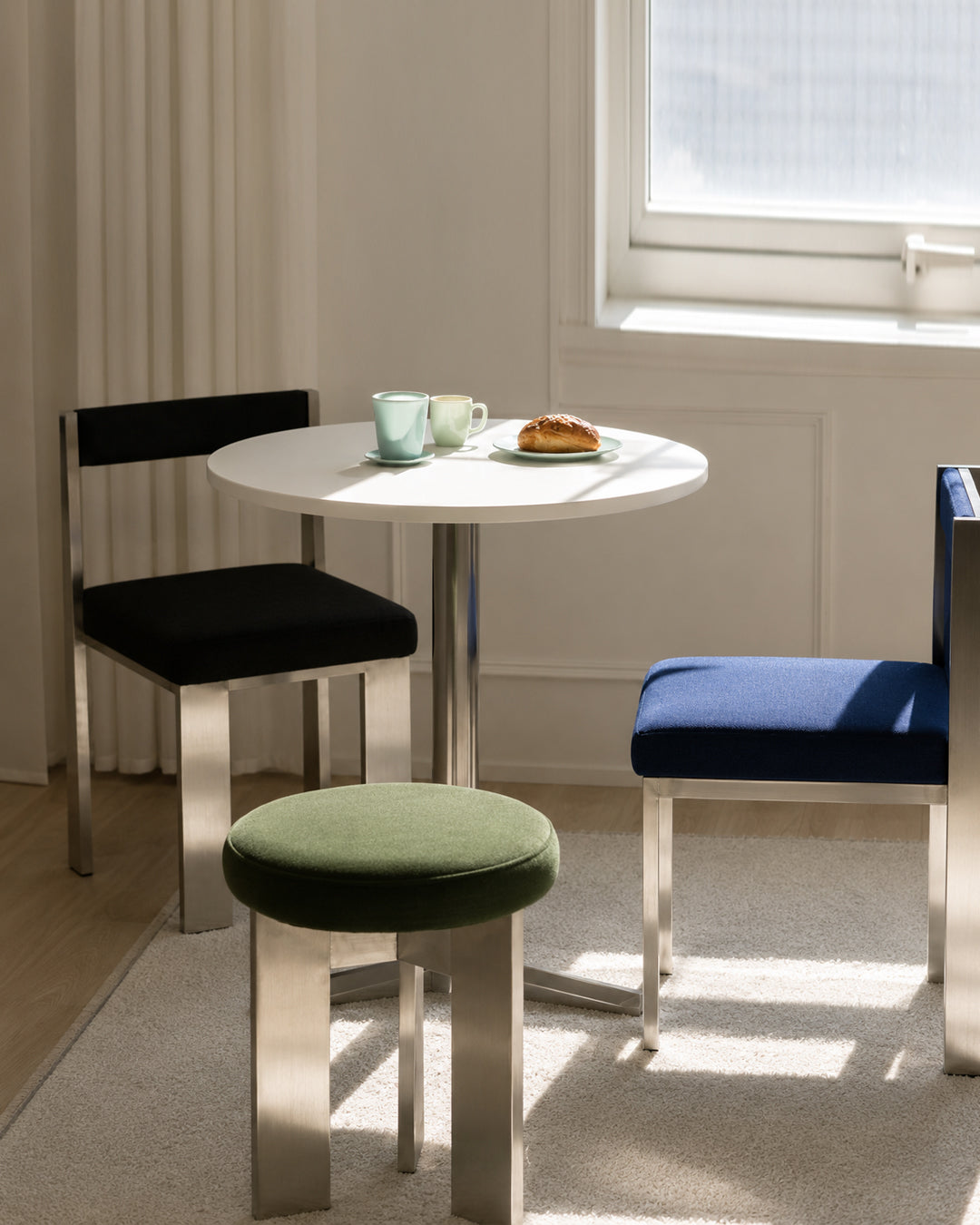 tripod stool shown grouped in mixed colors around a dining table