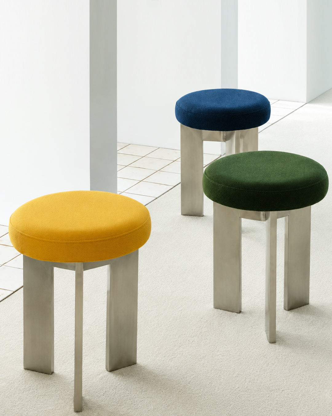 linen-top tripod stool closeup detail shot showing upholstered seat texture