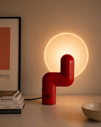 Articulating pipe lamp projecting circular light halo on wall