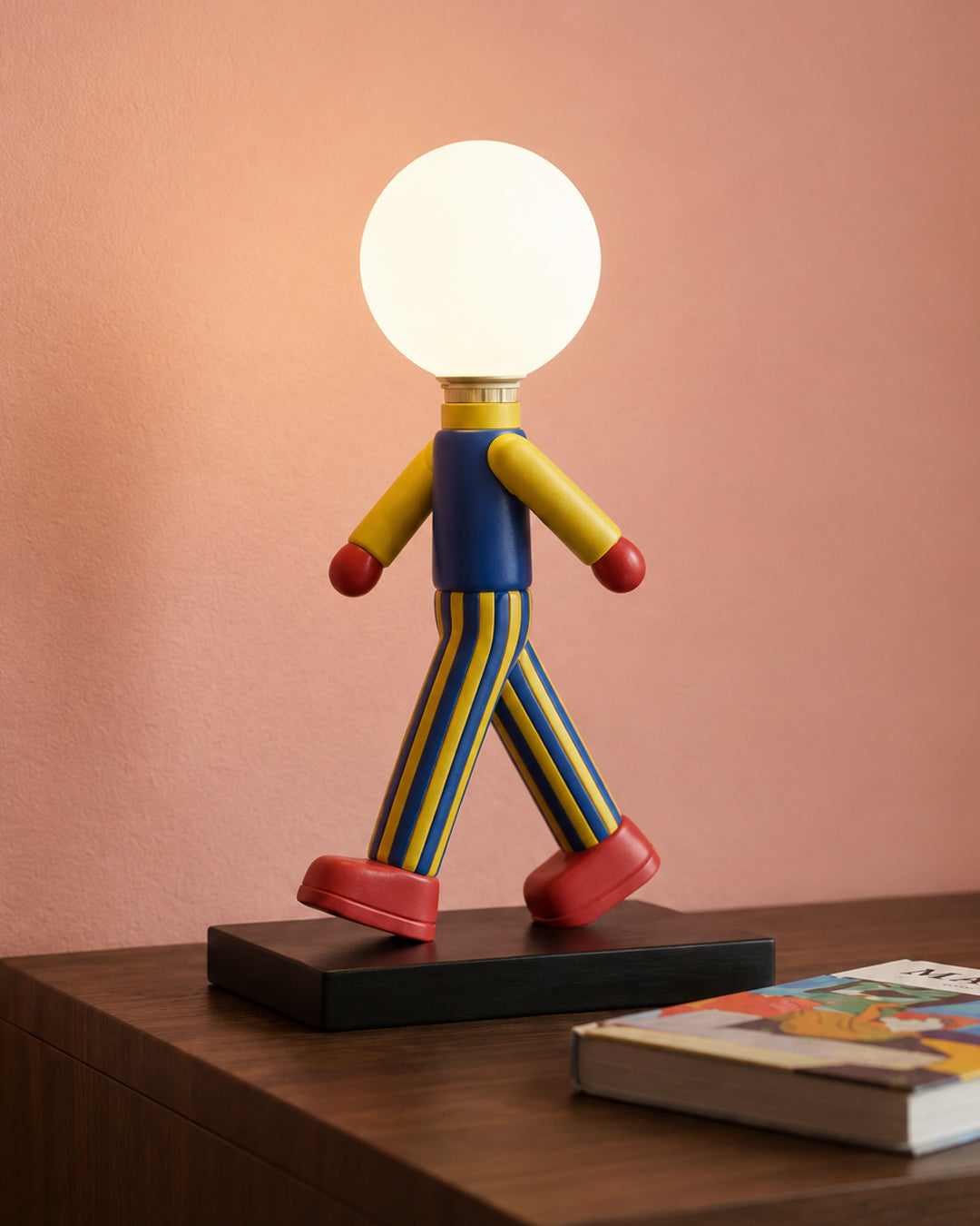 Resin figure table lamp illuminated, showing warm glow