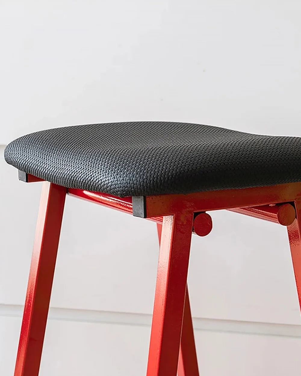 saddle seat bar stool closeup shot showing padded seat cushion stitching