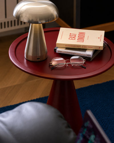 cone base accent table shown as a bedside surface