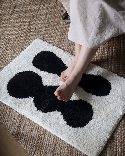 Biomorphic tufted doormat styled at a home entryway