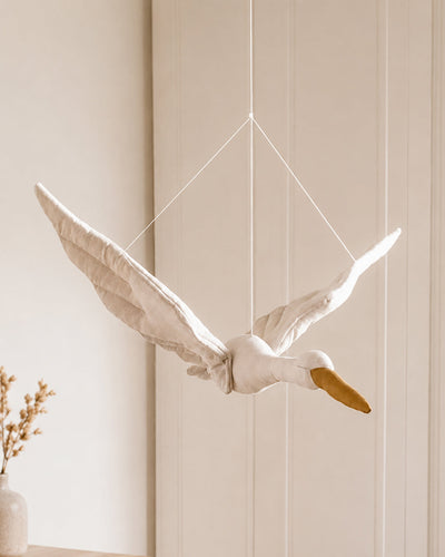 Stork mobile hanging in a nursery ceiling setting