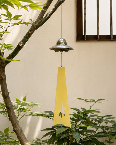 UFO wind chime hanging in a courtyard setting