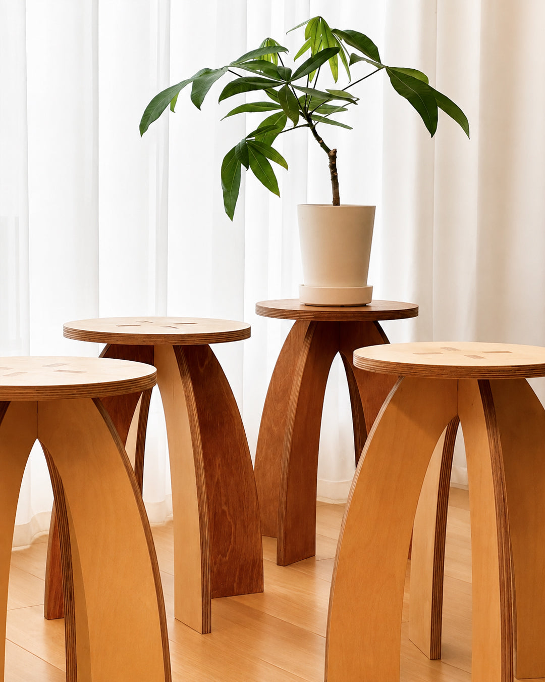 arched wood side table shown styled beside a sofa as a plant stand